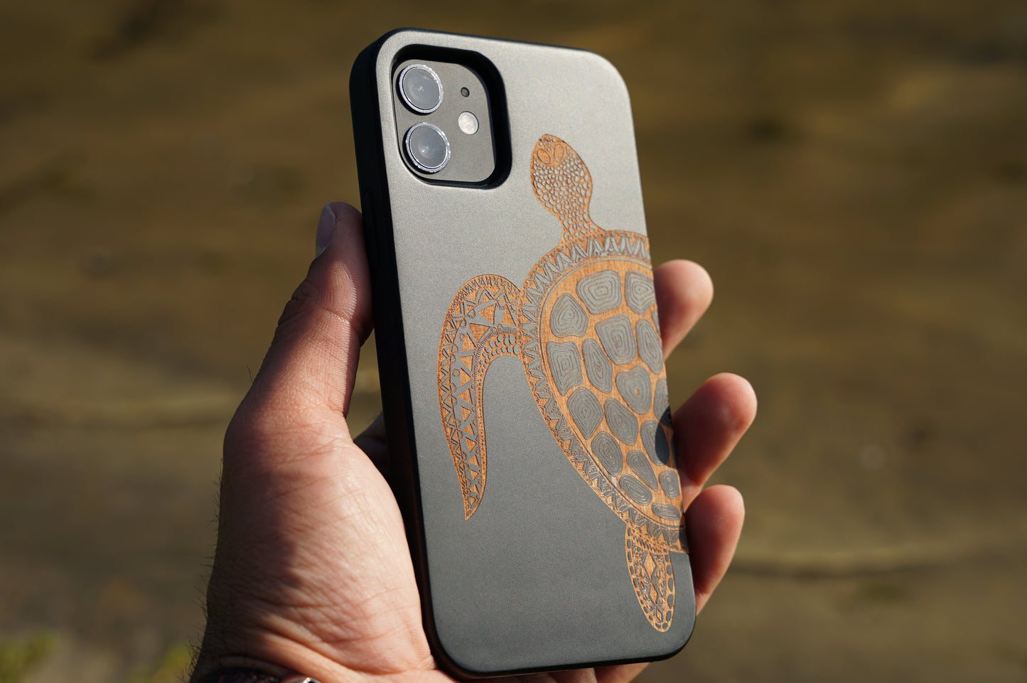 Eco-friendly wooden iPhone case with a detailed laser-engraved turtle design, MagSafe-compatible for easy wireless charging.