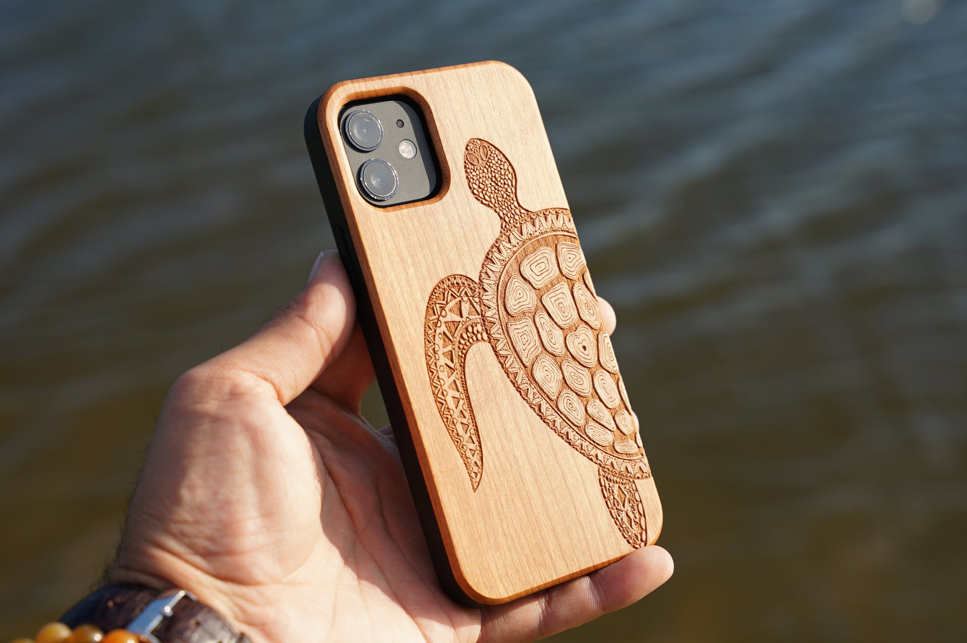 Eco-friendly wooden iPhone case with a detailed laser-engraved turtle  design, MagSafe-compatible for easy wireless charging.